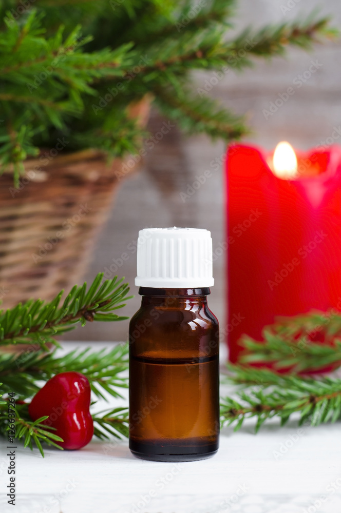 Small bottle of essential oil and fir branches. Christmas or Valentine's gift. Aromatherapy and spa concept. Small bottle of essential oil and fir branches. Christmas or Valentine's gift. Aromatherapy and spa concept.