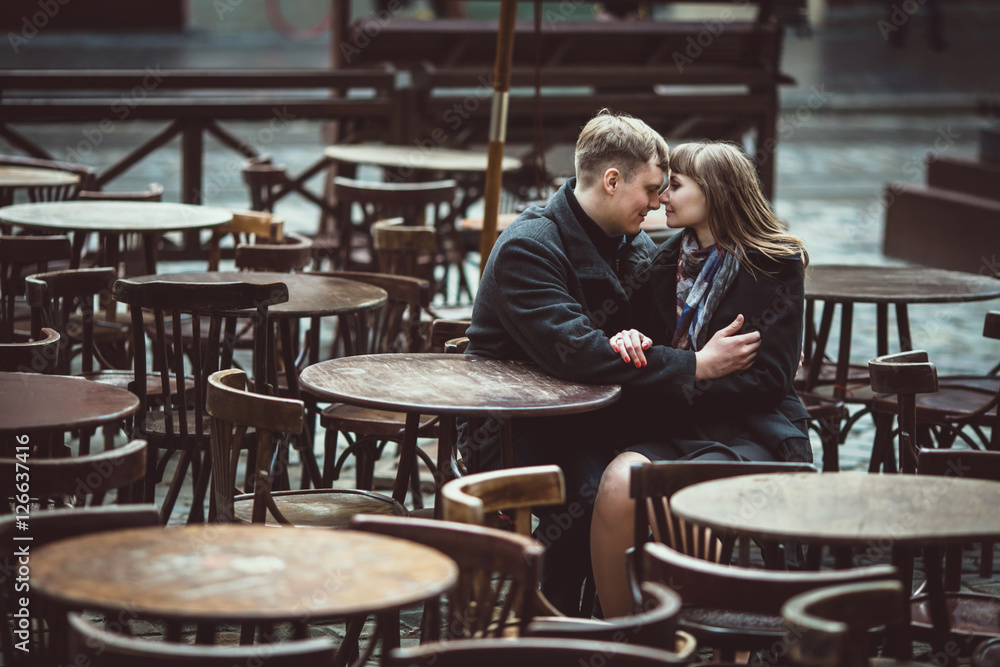 beautiful and young couple sitting outside a cafe