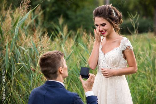 Young man makes a proposal to get married, the bride is crying from happiness