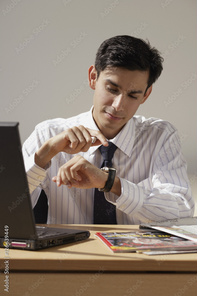 A man looks at his watch to check the time A man looks at his watch to check the time