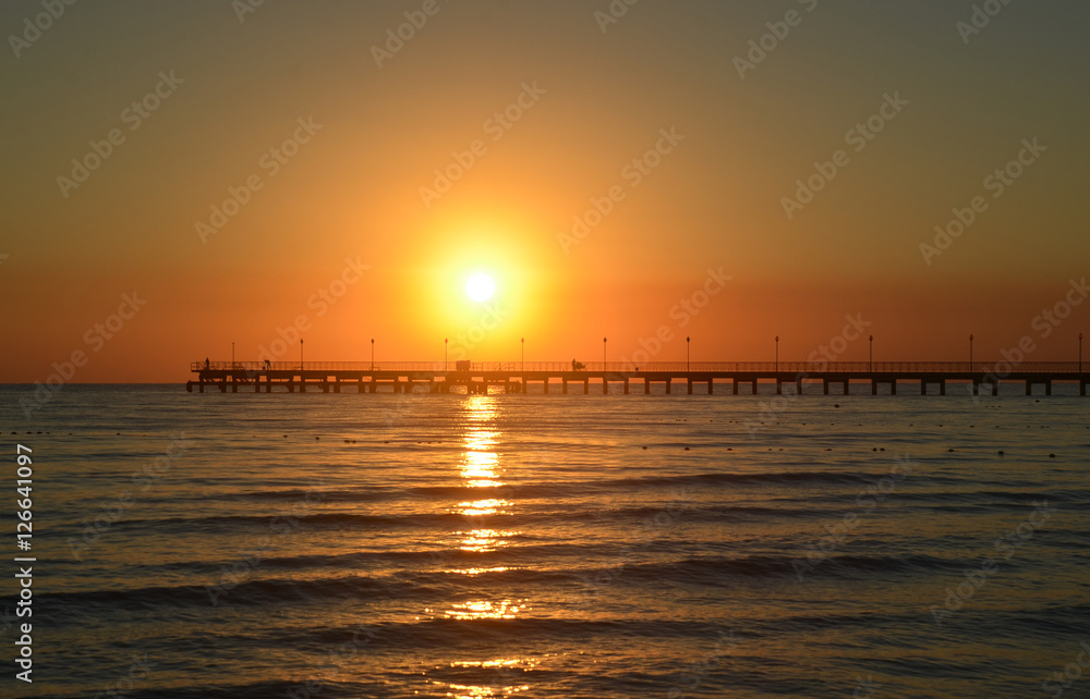 Sea pier in Black Sea resort village in evening at sunset