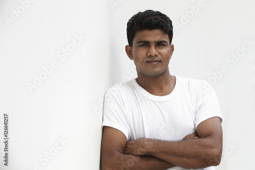 Man leaning against white wall