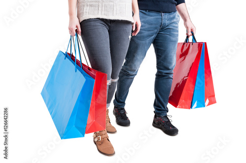 Couple holding bunch of shopping bags and walking