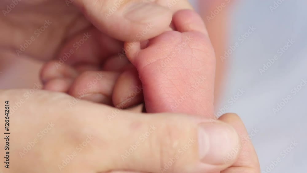 Close up of little baby feet in hands of mother.
Close up of little baby feet in hands of mother.