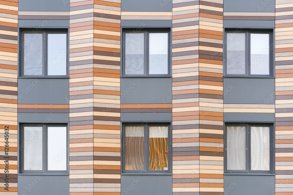 Fototapeta premium Grey and brown facade of the building with windows, background