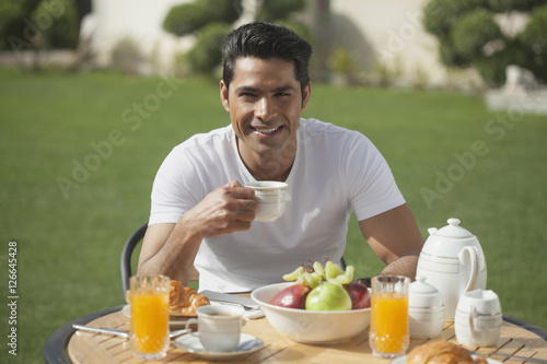 Photography India, Man in white t-shirt having breakfast in garden