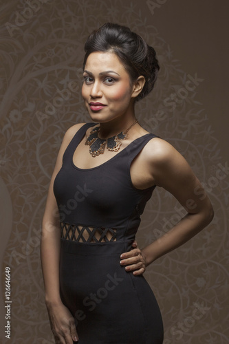India, Woman in black evening dress posing with hand on hip