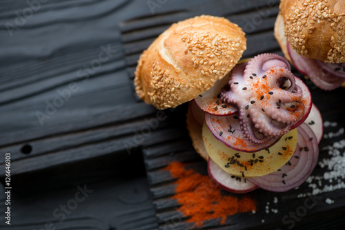 Galician style octopus burger on a black wooden serving board
