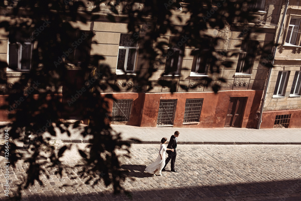 lovely wedding couple is walking down the street lovely wedding couple is walking down the street