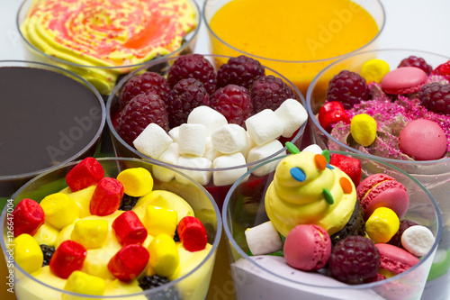 Dessert in plastic cups cream with fruit and pastries and mousse