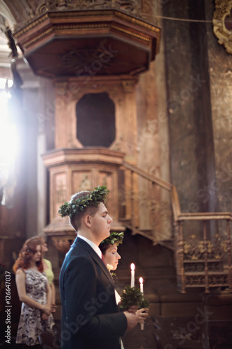  Tender wedding couple during wedding ceremony in church