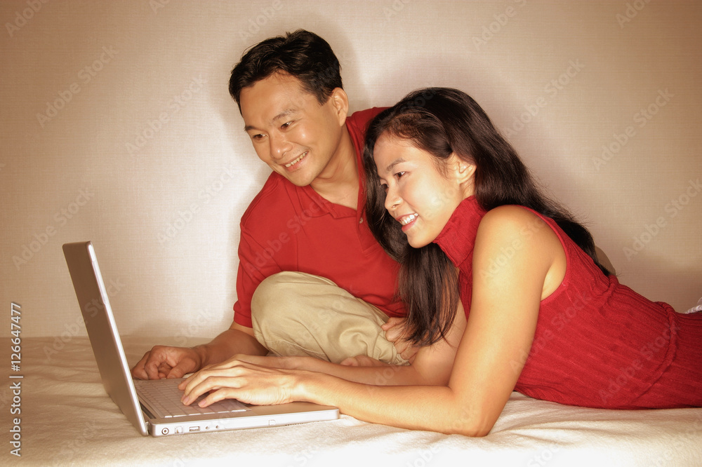 Man and woman side by side, using laptop Man and woman side by side, using laptop