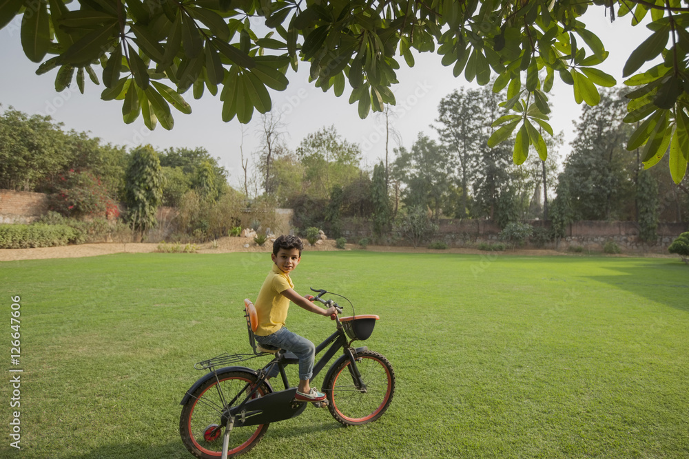 India, Young boy (4-5) cycling on backyard India, Young boy (4-5) cycling on backyard