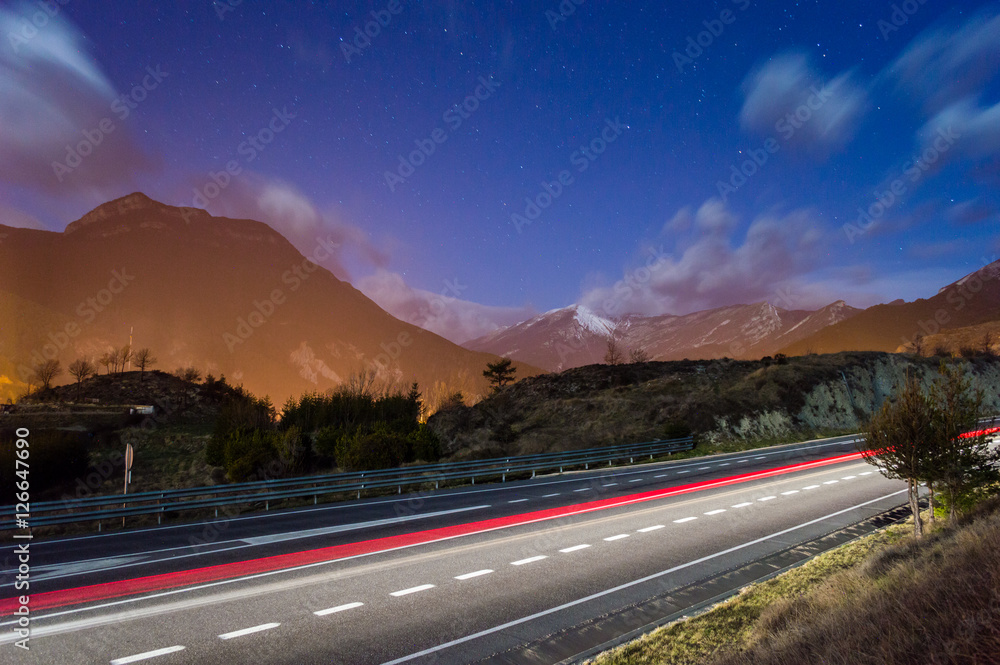 Light trails on motorway highway at night, long exposure in Pyrenees mountains, Catalonia, Spain