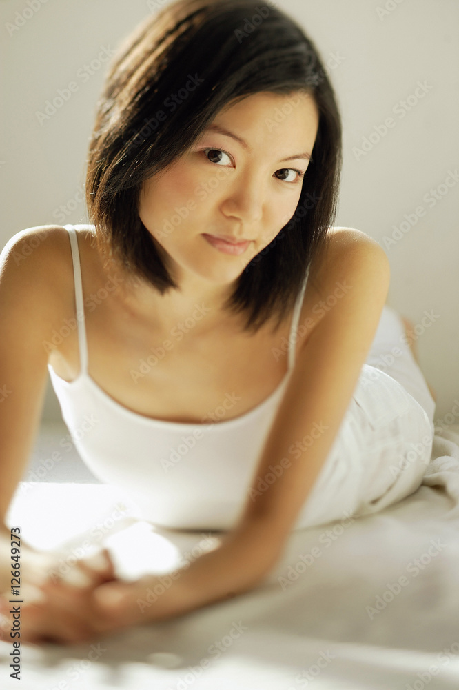 Young woman lying on front, looking at camera Young woman lying on front, looking at camera