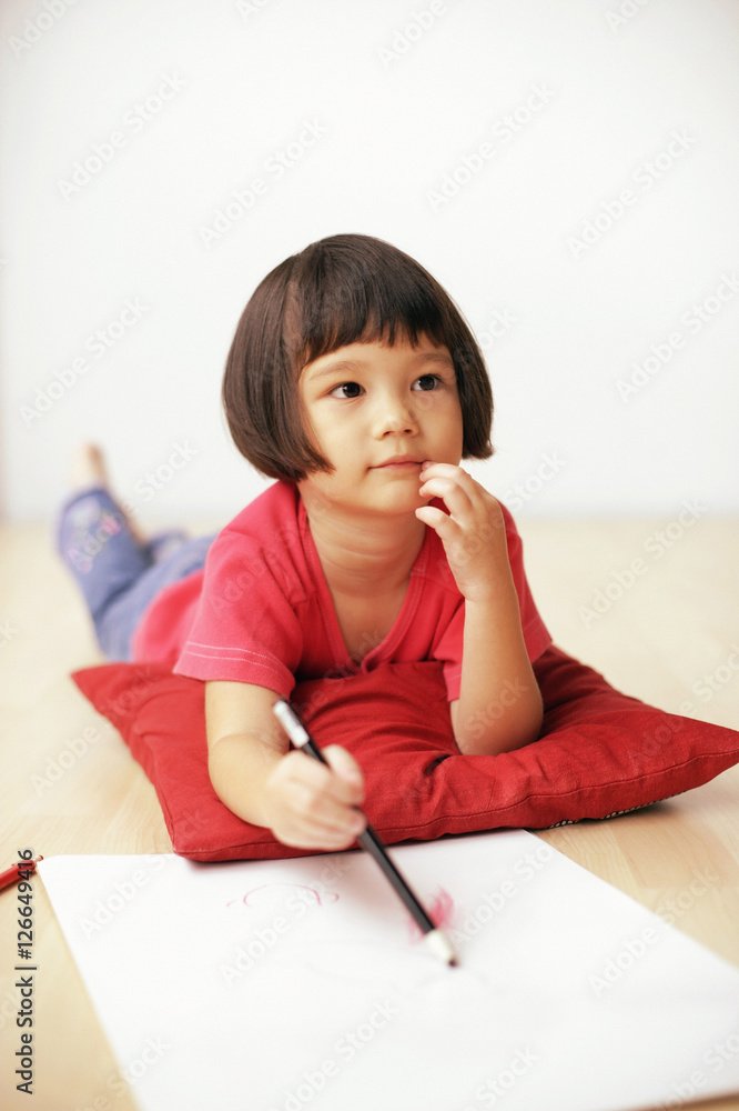 Young girl holding pencil, drawing on drawing pad Young girl holding pencil, drawing on drawing pad