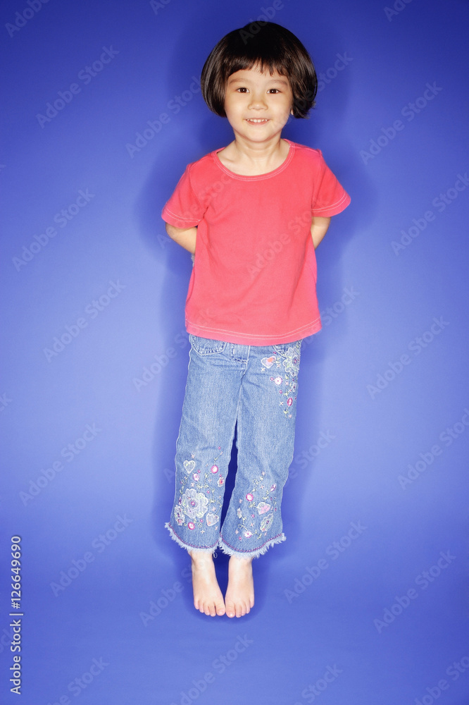 Young girl jumping, blue background Young girl jumping, blue background
