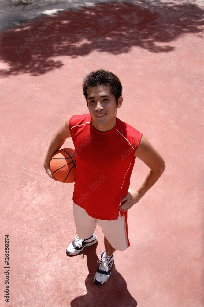 Man holding basketball, looking at camera