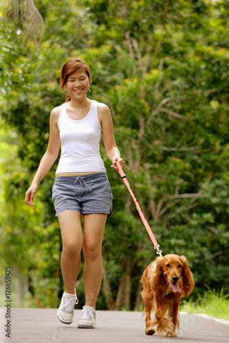 Young woman walking with her dog