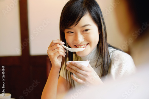 Obraz na płótnie Young woman holding bowl, eating soup w salonie