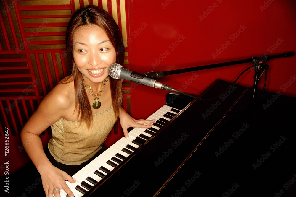 Woman singing and playing the piano
