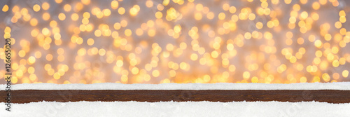 xams christmas panorama bokeh background with wooden snowy plank in front many bright lights photo