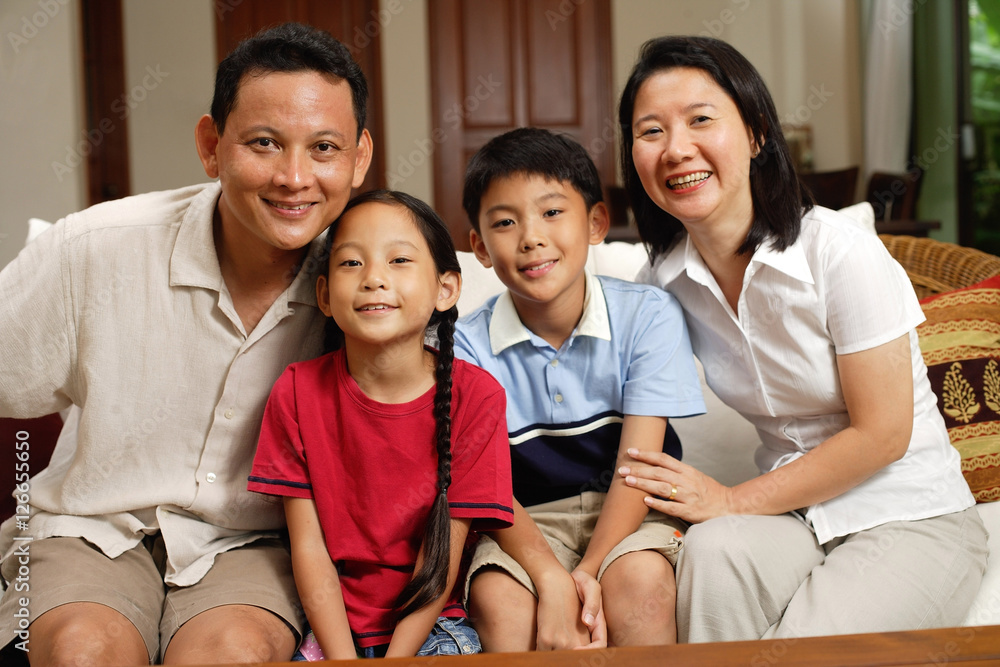 Family in living room, looking at camera, portrait
