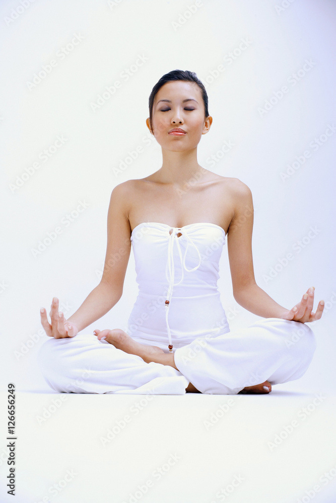 Woman dressed in white, eyes shut and legs crossed Woman dressed in white, eyes shut and legs crossed