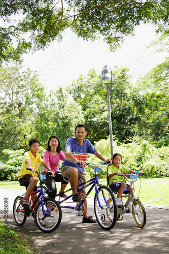 Family with two children, on bicycles, portrait