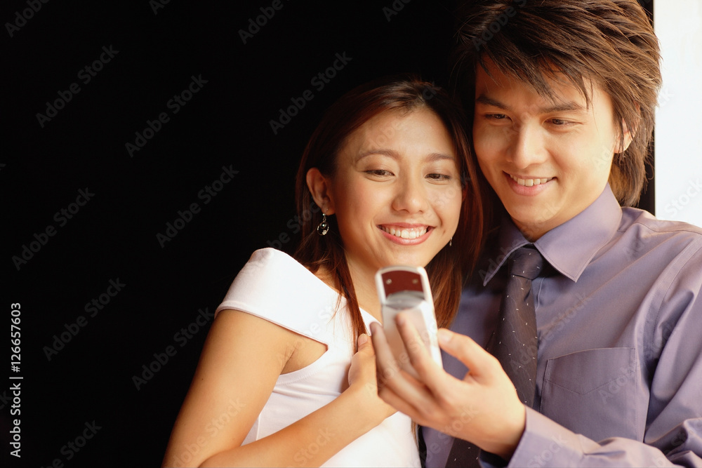 Couple looking at mobile phone, low angle view Couple looking at mobile phone, low angle view