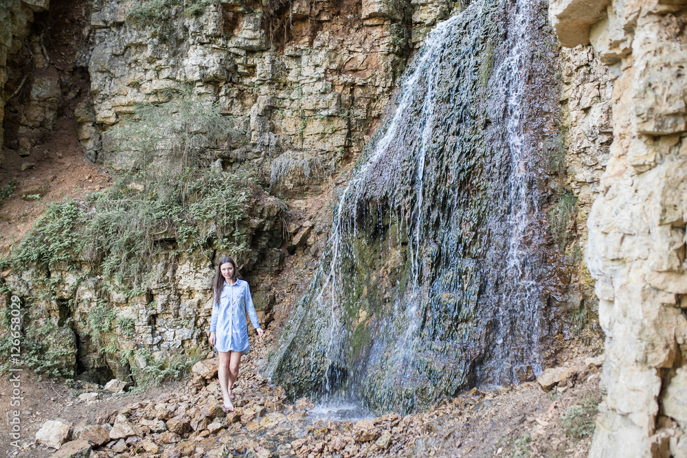 woman walking near the mountain waterfalls