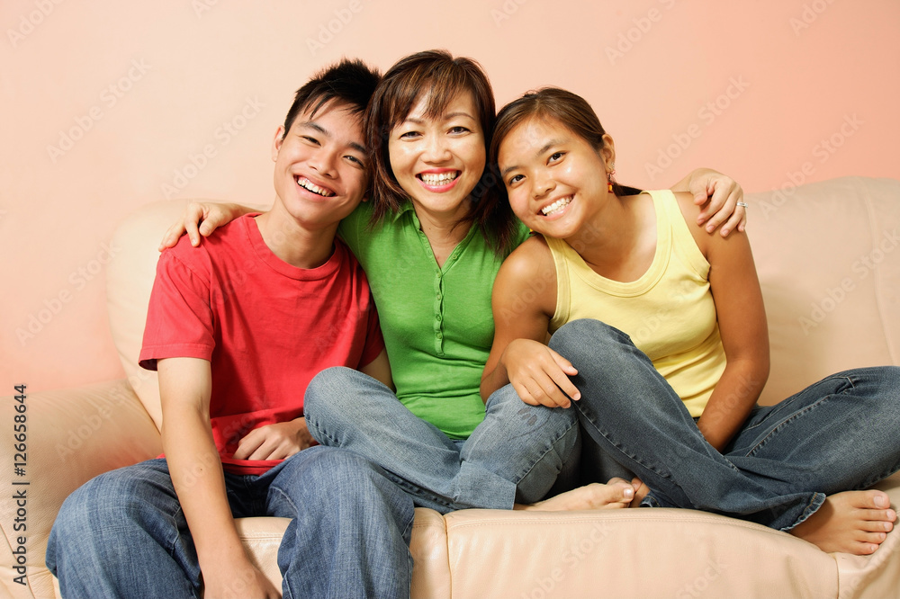Mother with son and daughter, sitting on sofa, smiling Mother with son and daughter, sitting on sofa, smiling