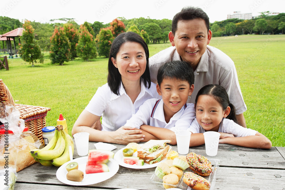 Family at picnic table, looking at camera, smiling Family at picnic table, looking at camera, smiling