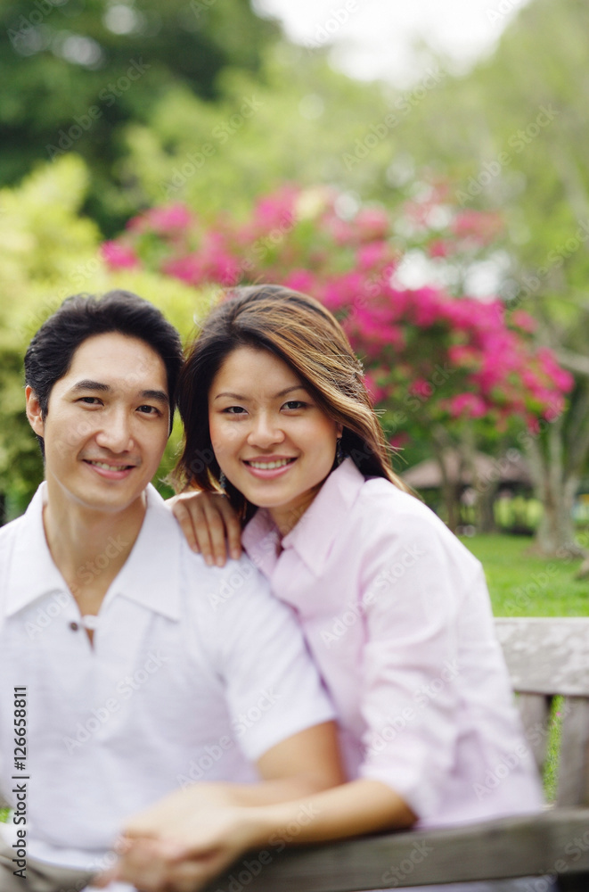 Couple looking at camera, sitting side by side Couple looking at camera, sitting side by side