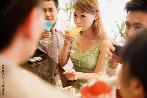 Group of young adults drinking at bar