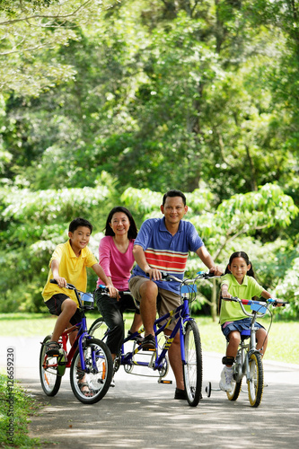 Family in park, riding bicycles