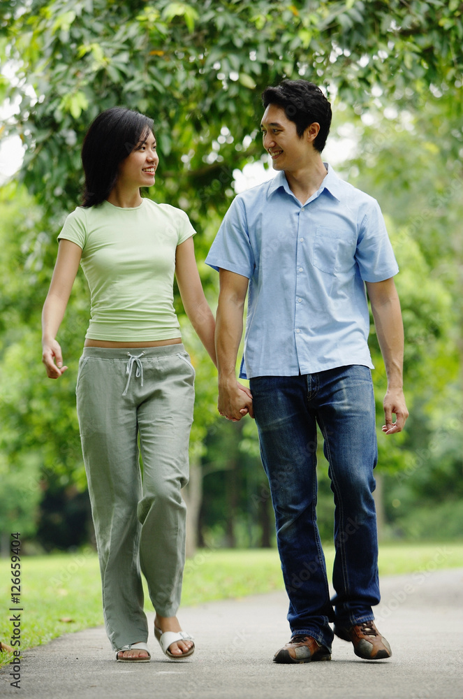 Couple holding hands and walking in park
