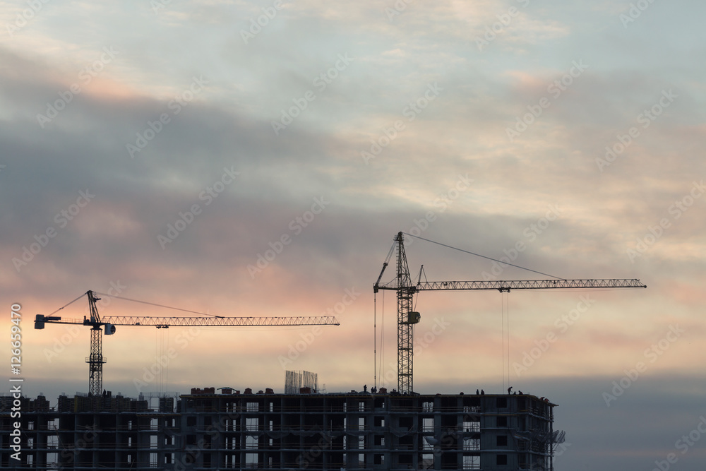 Construction site with cranes at sunset