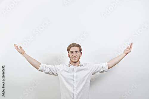 Young Adult Male in White Shirt Gesturing, Arms Raised, Wide Open