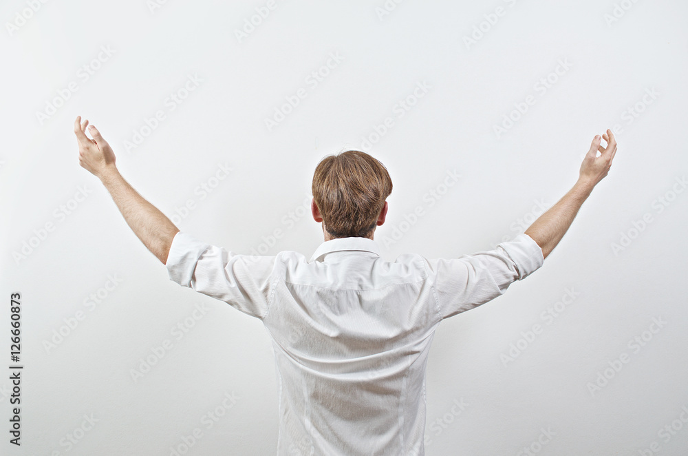 Young Adult Male in White Shirt Gesturing Arms Raised, Wide Open Young Adult Male in White Shirt Gesturing Arms Raised, Wide Open