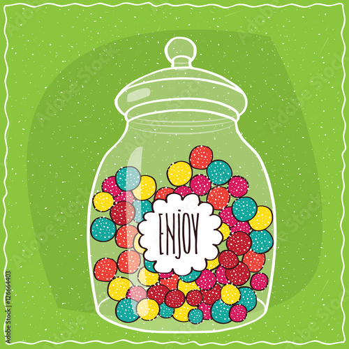 Large transparent glass jar with colorful round candies inside. Green background. Handmade cartoon style