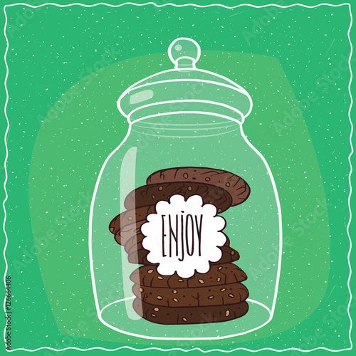 Foto Large transparent glass jar with stack of round chocolate cookies inside