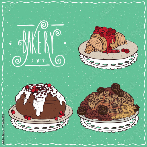 Pastry set. Croissant drizzled with syrup or jam of red berries, Cinnamon roll with white icing and red berries, Heap of different chocolate cookies and biscuits