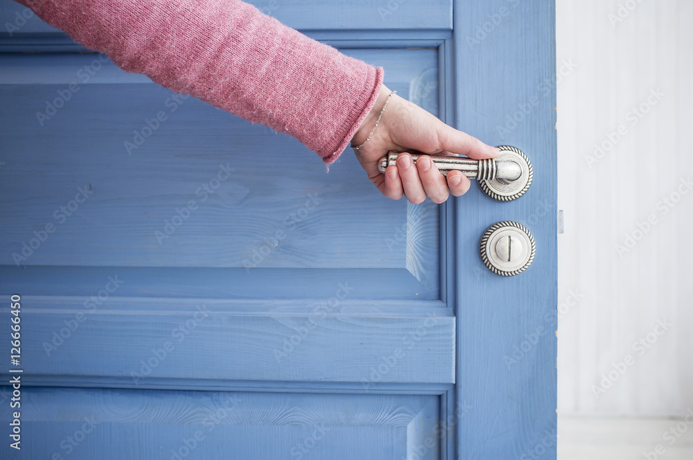 Fototapeta premium man holding a metal pen in an open wooden door blue