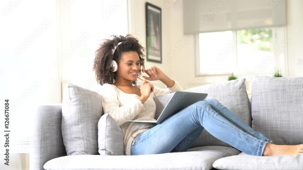 Cheerful woman making a videocall on laptop computer Cheerful woman making a videocall on laptop computer
