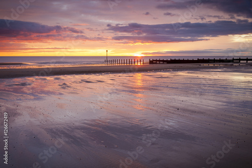 Dawn at South Beach  Blyth  Northumberland. Showing sunrise and groynes on sandy beach.