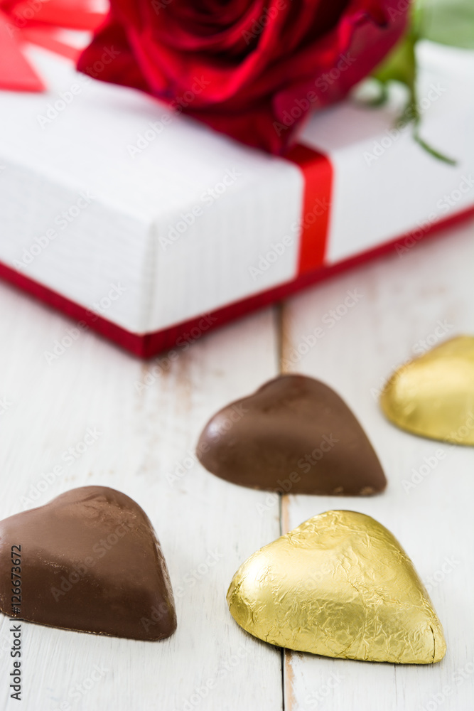 White gift box, roses and chocolate with heart shape on wooden table.copyspace
White gift box, roses and chocolate with heart shape on wooden table.copyspace