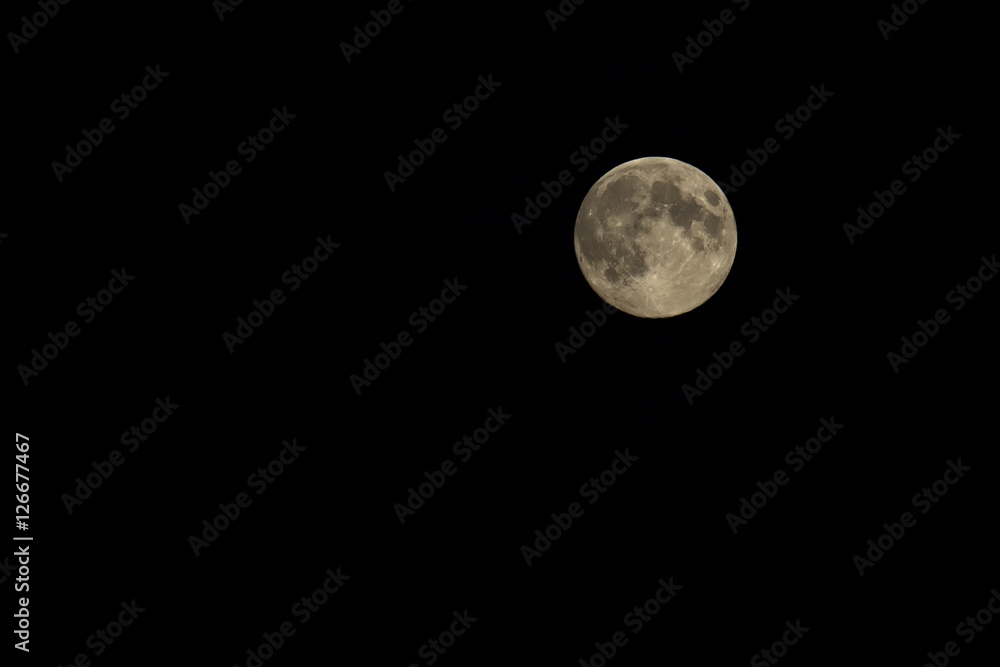 bright yellow full moon against the black night sky bright yellow full moon against the black night sky