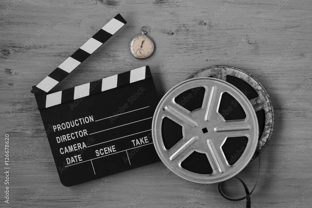 Clapperboards , two film reels and old clock