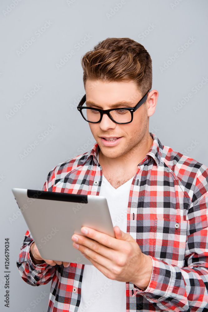 Handsome man in glasses using digital tablet to read news Handsome man in glasses using digital tablet to read news